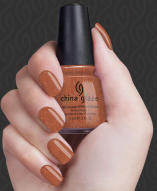 Hand with brown nail polish holding a China Glaze nail polish bottle against a dark background