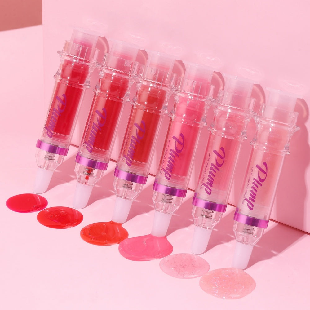Set of lip gloss tubes with visible brand name on a pink background