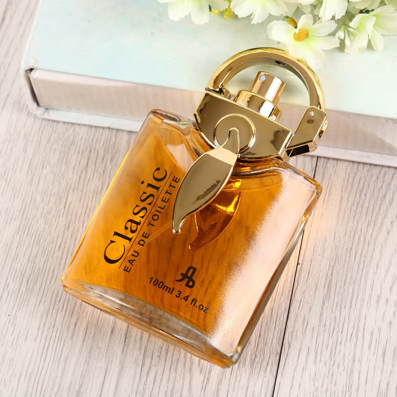Perfume bottle labeled 'Classic' on a wooden surface with flowers in the background