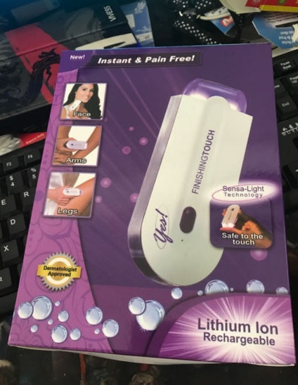 Purple packaging of a hair removal device with images and text on a blurred background