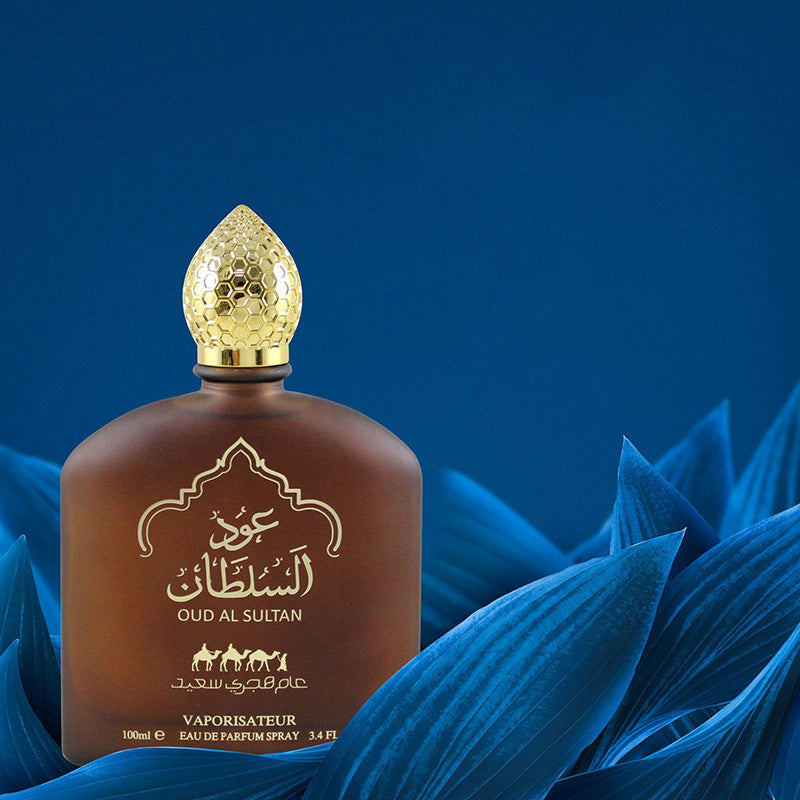 Brown perfume bottle with gold cap on blue leaves and background