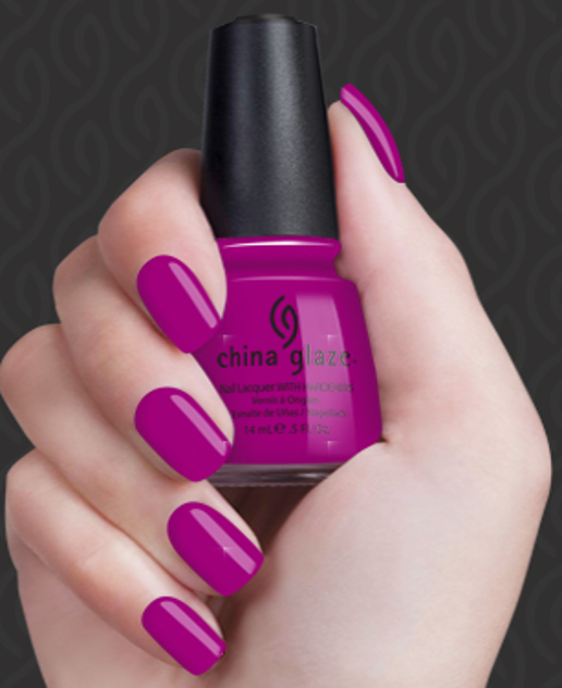 Hand holding a bottle of China Glaze nail polish with pink nails against a dark background